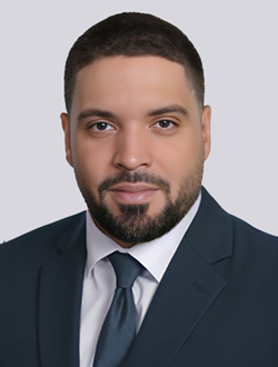 Professional man in a suit and tie with a neutral background.
