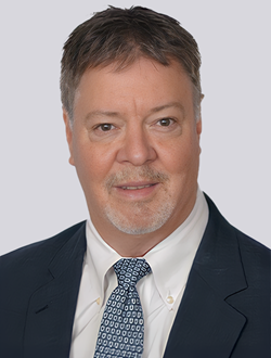 Businessman in a suit and tie with a light gray background.